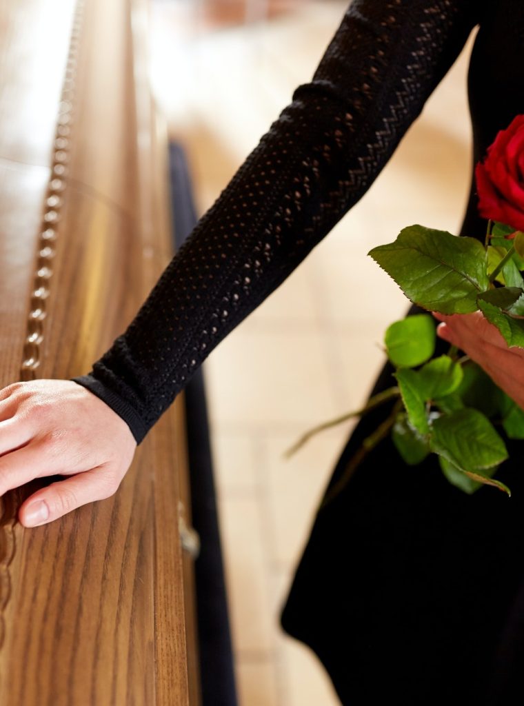 woman-with-red-roses-and-coffin-at-funeral-1.jpg